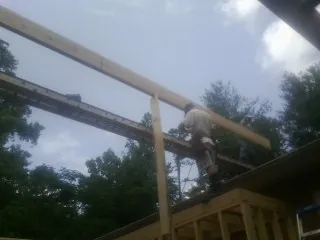 Carpenter setting a ridge beam over a new addition frame — Ice Dam Removal by Roofing Brothers in Belmar