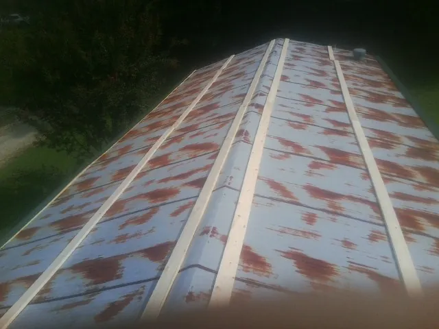 Rusted metal roof panels with new wood purlins before replacement — Storm Damage Roof Repair in Belmar by Roofing Brothers