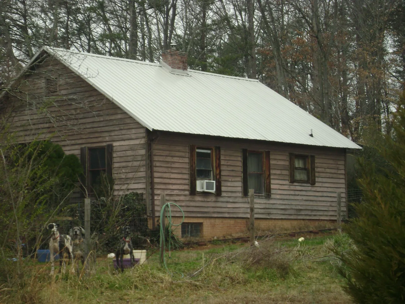 White metal roof on an old wood sided farmhouse, from a Metal Roof Installation job in Belmar